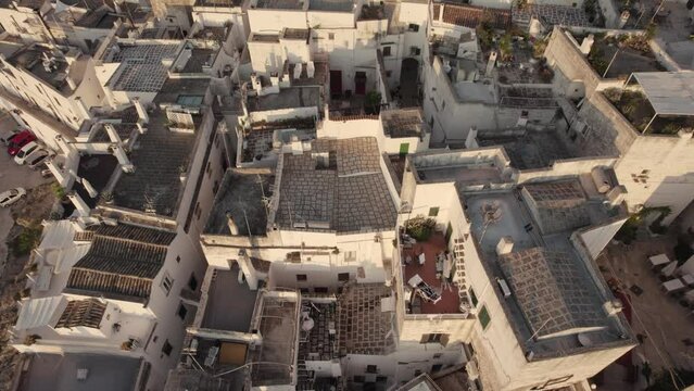 Drone flying backwards with the camera tilting up slowly filming the old white city Ostuni in the south of Italy in 4k.