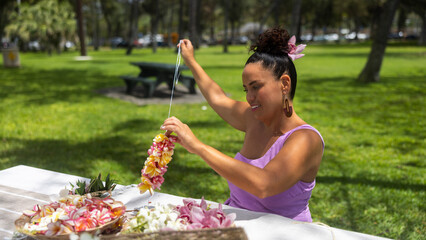 Woman making Hawaiian Lei and Hahu. Process of Handmade flower crown made from Hawaii flower...