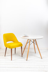 minimalistic interior, yellow armchair and white round table on white background