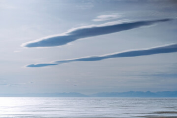 Clouds over a frozen airship-shaped lake at sunset.