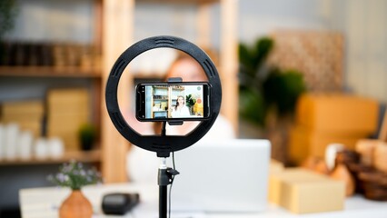 Record live video and sharing product promotion on social media with ring light and smartphone...