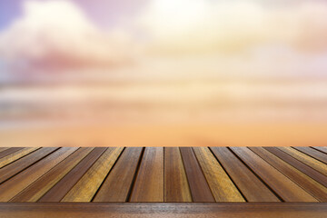 Teak wooden table top setting against sea wave light  blurred background.	