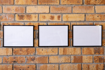 White empty frames with copy space against brick wall