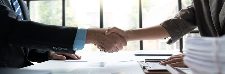 Two confident businessmen shaking hands during meeting in office and mutual investment in financial...