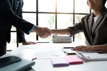 Two confident businessmen shaking hands during meeting in office and mutual investment in financial business that fits and succeeds in office.