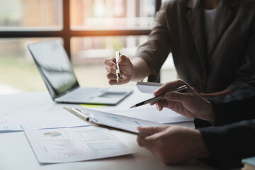 Work team meeting concept with financial plan, meeting, discussion, brainstorming and pointing to graph data sheet. Business turnover chart on office desk.