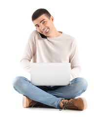 Handsome guy with laptop talking by mobile phone on white background