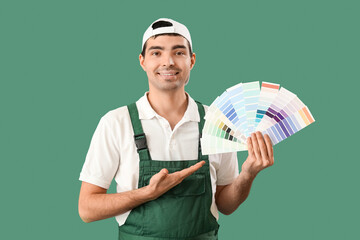 Male painter showing color palettes on green background