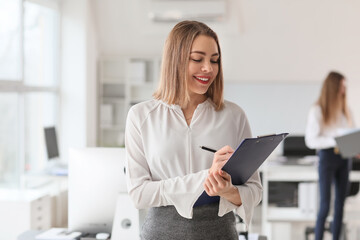 Female accountant with clipboard in office
