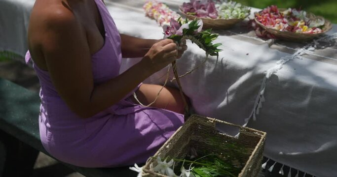 Woman making Hawaiian Lei and Hahu. Process of Handmade flower crown made from Hawaii flower Plumeria.