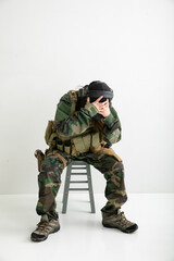 迷彩服を着て頭を抱える女性