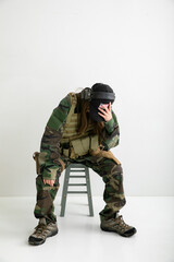 迷彩服を着て頭を抱える女性