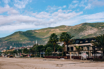 Hotels and cafes on the beach with mountains in the background