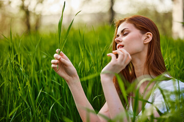 woman resting sitting in tall grass on a sunny day