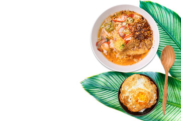 Spicy pork noodle soup with rice and fried egg on green leave with space on white background, Asian food background, egg noodle with clear soup