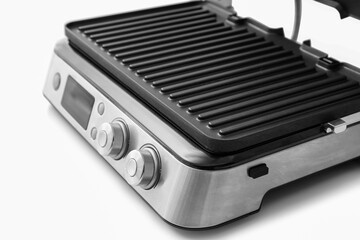 Modern electric grill with open lid on white table, closeup