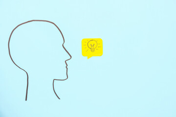 Drawn human head and speech bubble with light bulb on blue background. Insight concept