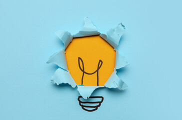 Drawn light bulb with torn blue paper, top view