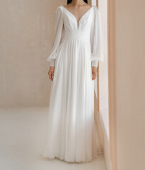 Beautiful bride in the white wedding dress with cleavage and long fancy sleeves. Gorgeous classic longsleeve wedding dress