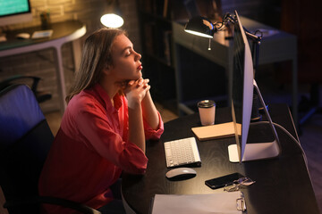 Tired female programmer working in office at night
