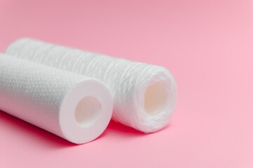 filter cartridges for water on a pink background. Installation of reverse osmosis water purification system.