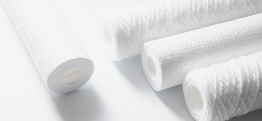 Cartridges for water treatment systems on white background.