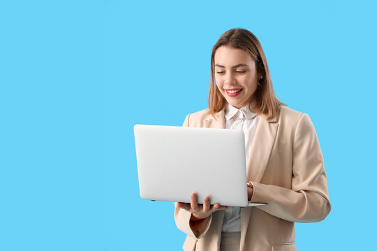 Female programmer working with laptop on blue background