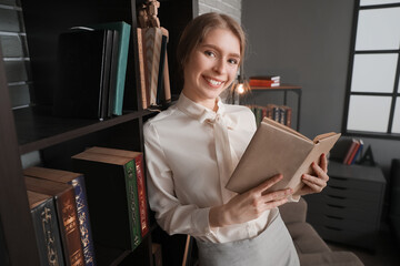 Young businesswoman reading book in office