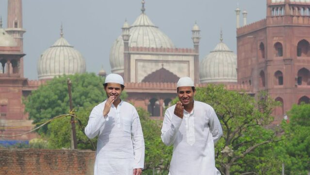 Muslim friends adab towards camera while standing in front of Jama Masjid Delhi