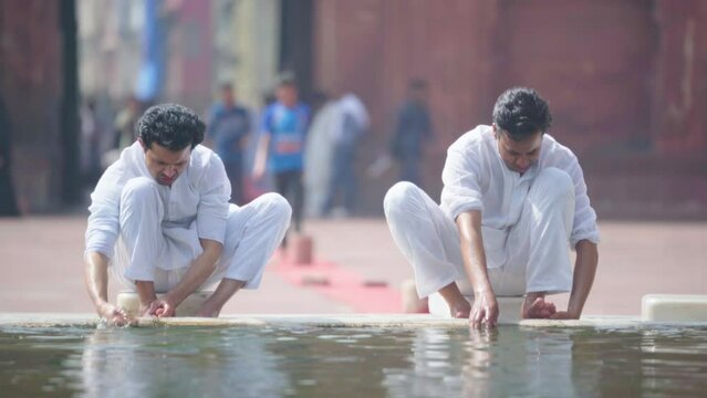 Wuzu cleansing being done at a mosque by two Indian Muslims before praying
