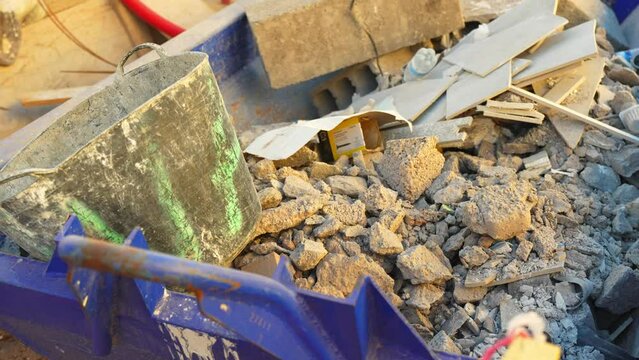 Blue garbage removal skip full of rubbish ready for collection in street