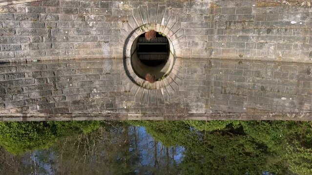 Circular water tunnel reflects portal stone wall. One circle holistic symmetry. Perfection. Holy trinity origin concept. Drain system canal. Parallel dimension alternate reality perception