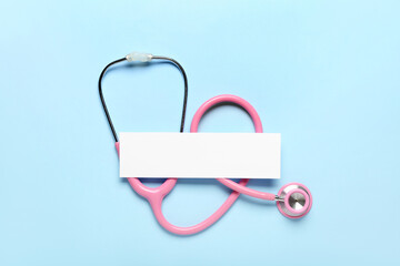 Obraz premium Blank sheet of paper and stethoscope on color background. Melanoma concept