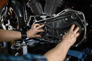 Man mechanic fixing motorcycle engine working at garage workshop