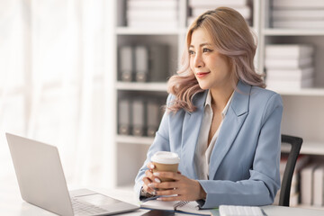 Obraz premium Portrait of Asian business woman holding coffee cup with work in workplace office Business documents money financial planning concept