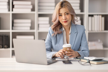 Portrait of Asian business woman holding coffee cup with work in workplace office Business...