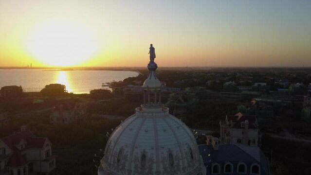 Colorful orange city skyline as aerial orbits dome building at sunset