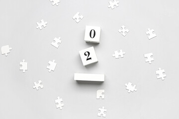 Date of World Autism Awareness Day with puzzle pieces on grey background
