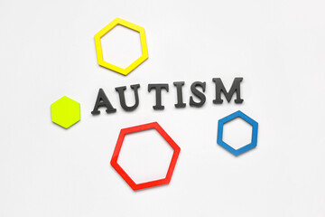 Word AUTISM with baby blocks on grey background