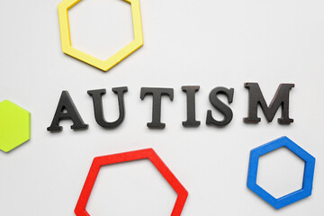 Word AUTISM with baby blocks on grey background