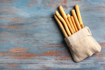 Sack bag with tasty Italian Grissini on blue wooden background