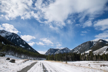 Lonely isolated snowy forest dirt road at base of mountains on a Winter morning near Red Lodge, MT