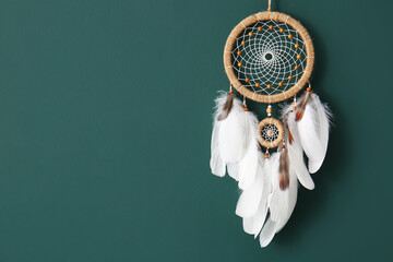 Dream catcher hanging on green wall