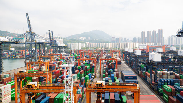 Hong Kong - 01.19.2023 Storage Yard Of Hong Kong International Container Terminal With Gantry Cranes And Big Quantity Of Cargo Containers With City Scape And Sky Scrappers On Background.