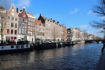 Fototapeta na wymiar canal, river and old brick houses or flat buildings in amsterdam (the netherlands) 