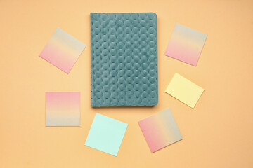 Sticky notes and notebook on beige background