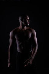 Obraz na płótnie Canvas Portrait of an athletic african american man topless, black background
