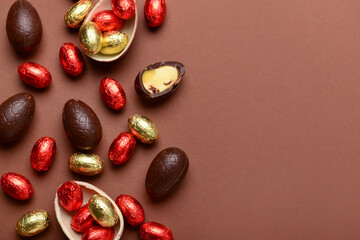 Chocolate Easter eggs and candies on brown background