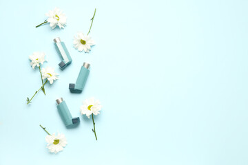 Asthma inhalers with daisy flowers on blue background