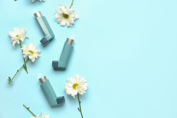 Asthma inhalers with daisy flowers on blue background